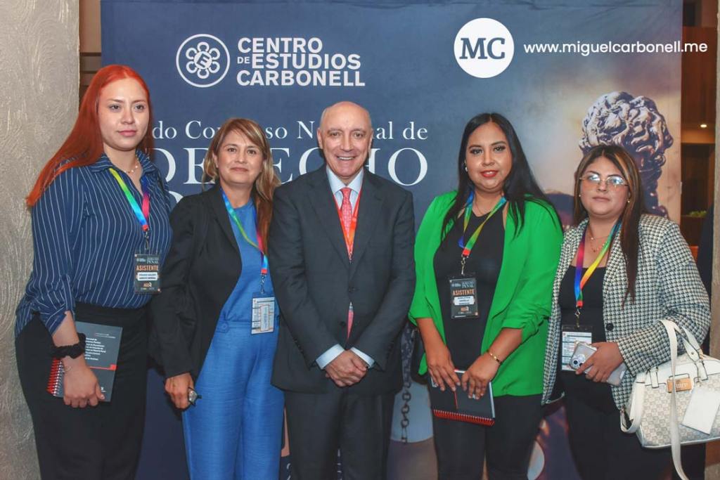 Grupo de cinco personas posando frente a un fondo con el logo del Centro de Estudios Carbonell en un evento relacionado con el derecho.